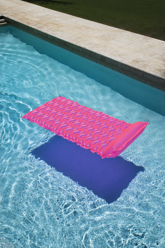 Materassino rosa gonfiabile su acqua della piscina
